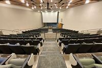 Front of room view with lectern center in front and projection screen lowered