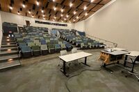 Back of room view of student auditorium seating and three exits at rear of room