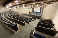 Front of room view with lectern in front and projection screen lowered