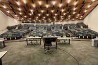 Back of room view of student auditorium seating and three exits at rear of room