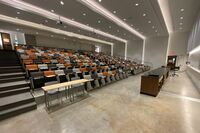 Back of room view of student auditorium seating and exit door at right side rear of room