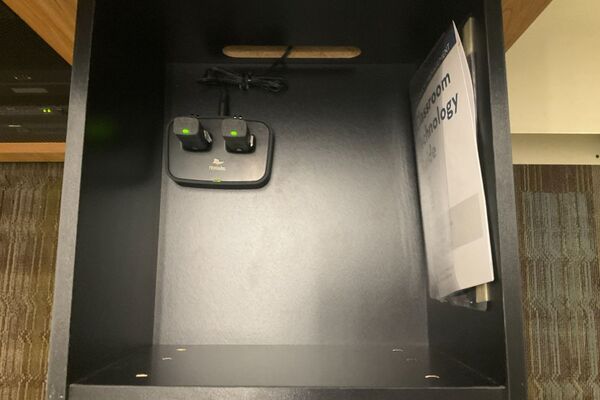 Pedestal - inside view of drawer showing two wireless mics in charging base