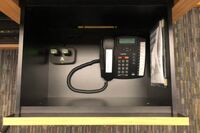 Pedestal - inside view of drawer showing two wireless mics in charging base and telephone