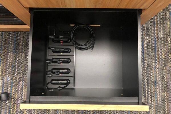 Pedestal - inside view of drawer showing assistive listening devices in charging base