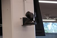 Camera mounted to a wall and instructor enabled adjustments to the lens to allow the instructor to be "seen" by the camera in more locations around the room