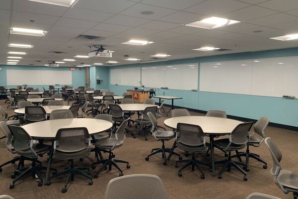 Front of room view with lectern center in front of markerboard, markerboard on wall near exit door