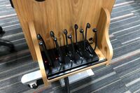 Pedestal - inside view of drawer showing two wireless mics in charging base and assistive listening devices in charger