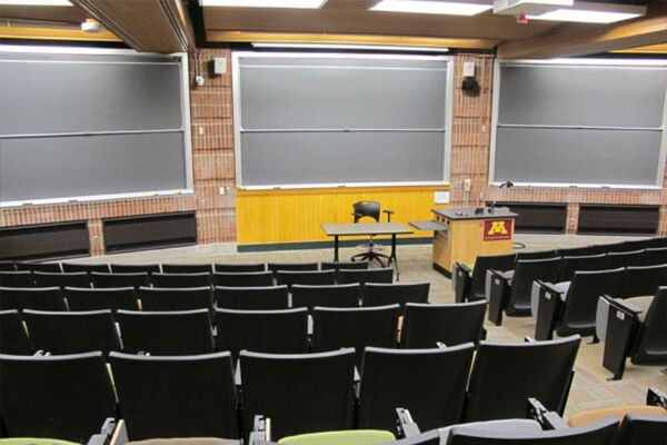 Front of room view with lectern on right side and projection screen fully raised