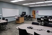 Front of room view showing pedestal in front of markerboard, exit on right