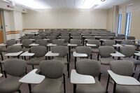 Back of room view of student tablet arm seating and exit door on left wall of room