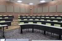  Back of room view of student tiered fixed-table and chair seating