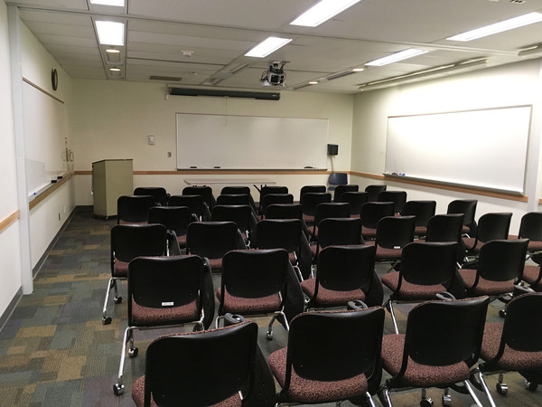 Photo of front of room from back of room with tablet armchairs on casters.