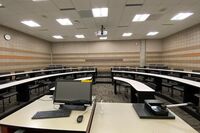 Back of room view of student tiered fixed-table and chair seating