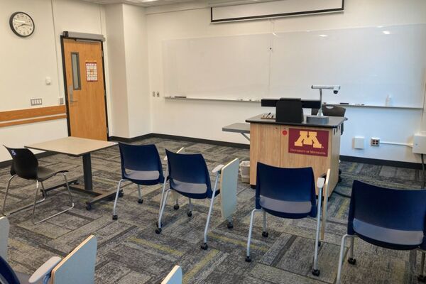 Front of room view with lectern on right in front of markerboard 