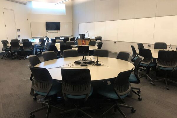 View of room with lectern on left in front of markerboard and display monitor on back wall