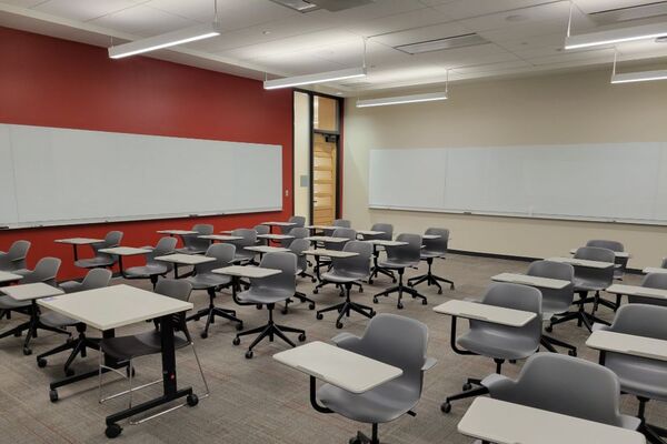 Back of room view of student tablet arm seating and exit door at left rear of room