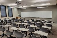 Front of room view with lectern on left in front of markerboard 