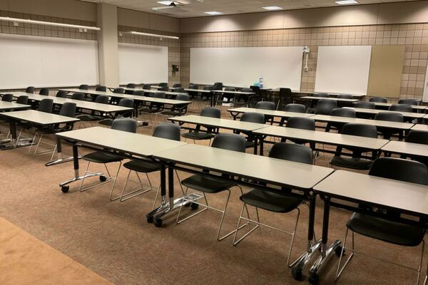 Back of room view of student table and chair seating and markerboards