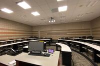 Back of room view of student tiered fixed-table and chair seating 