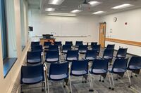 Front of room view with lectern on left in front of markerboard 