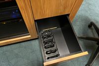 Pedestal - inside view of drawer showing assistive listening devices in charging base