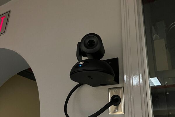 Camera mounted to a wall and instructor enabled adjustments to the lens to allow the instructor to be "seen" by the camera in more locations around the room