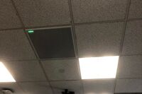 White 2x 2 tile mounted in the ceiling to provide microphone coverage over student seating