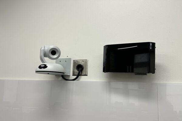 Camera mounted to a wall and instructor enabled adjustments to the lens to allow the instructor to be "seen" by the camera in more locations around the room