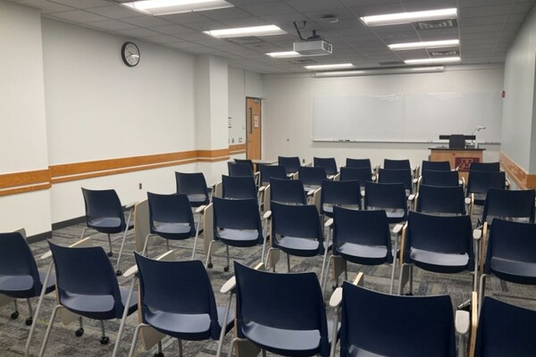 Front of room view with lectern on right in front of markerboard 