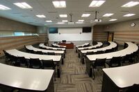 Front of room view with lectern center in front of markerboard and display screen to the left and right