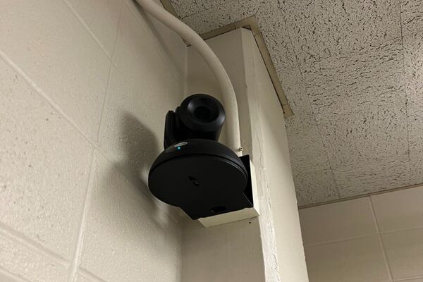 Camera mounted to a wall and instructor enabled adjustments to the lens to allow the instructor to be "seen" by the camera in more locations around the room