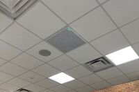 White 2¿ x 2¿ tile mounted in the ceiling to provide microphone coverage over student seating