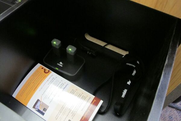 Pedestal - inside view of drawer showing two wireless mics in charging base