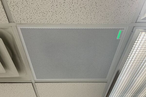 White 2 x 2 tile mounted in the ceiling to provide microphone coverage over student seating