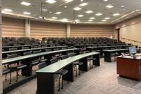 Back of room view of student tiered fixed-table and chair seating