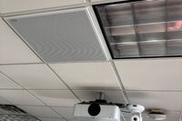 White 2¿ x 2¿ tile mounted in the ceiling to provide microphone coverage over student seating