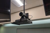 Camera mounted to a wall and instructor enabled adjustments to the lens to allow the instructor to be "seen" by the camera in more locations around the room