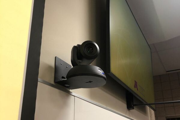 Camera mounted to a wall and instructor enabled adjustments to the lens to allow the instructor to be "seen" by the camera in more locations around the room