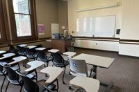 Front of room view with lectern on left in front of markerboard