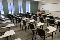 Front of room view with lectern on left in front of markerboard