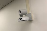 Camera mounted to a wall and instructor enabled adjustments to the lens to allow the instructor to be "seen" by the camera in more locations around the room