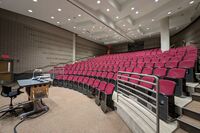 Back of room view of student auditorium seating and double exit doors at rear of room