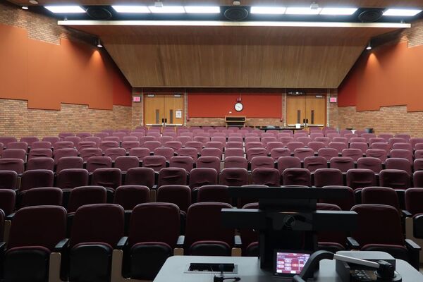 Back of room view of student auditorium seating and double exit doors at rear of room