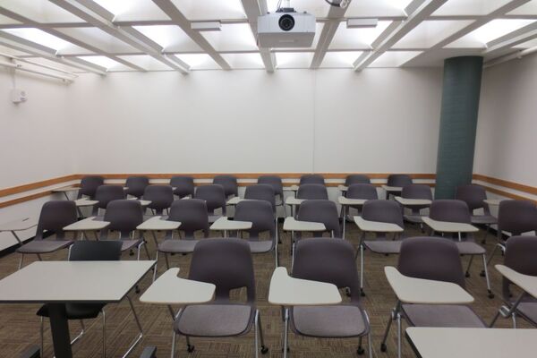 Rear of room view of student tablet arm chair seating on casters