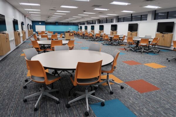 Front of room view with lectern center in front of markerboard and student displays on side walls to left and right