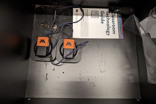 Pedestal - inside view of drawer showing two wireless mics in charging base