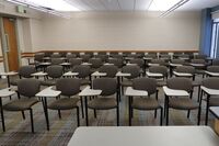 Back of room view of student tablet arm seating and exit door at left rear of room