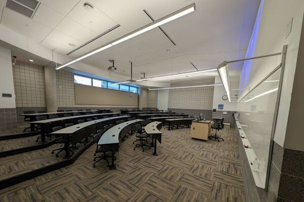 Back of room view of student tiered fixed-table and chair seating 