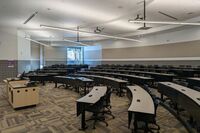 Back of room view of student tiered fixed-table and chair seating 