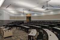 Back of room view of student tiered fixed-table and chair seating 